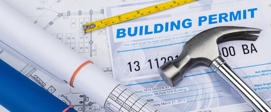 hammer laid on building plans and permits